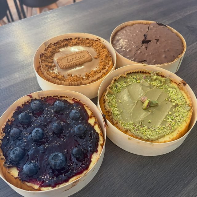 Cinco tartas de queso individuales en molde de papel: Lotus, chocolate, arándanos y pistacho.